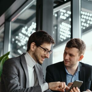 two-businessmen-having-conversation-using-smartphone-min